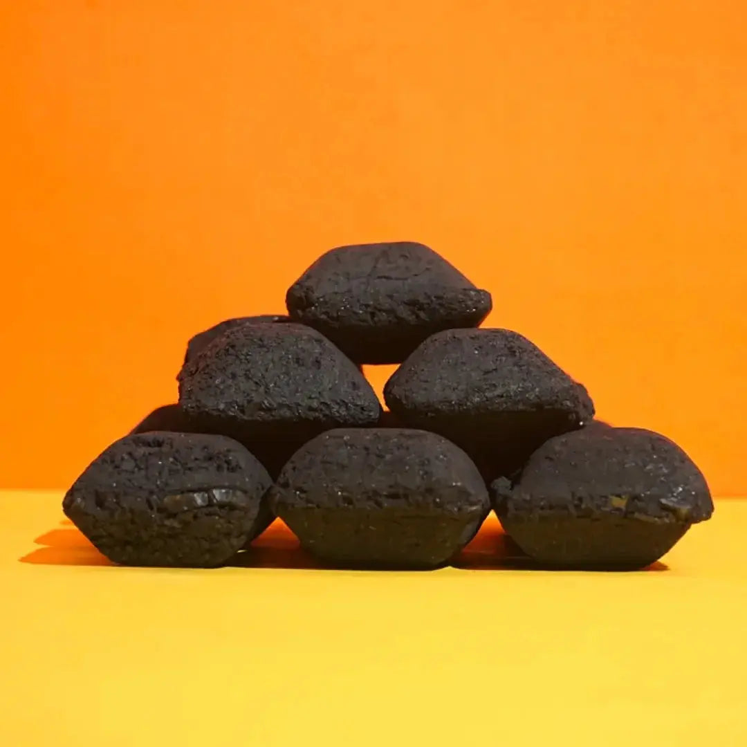 Stack of six black charcoal briquettes