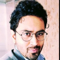 Person wearing glasses and a headset with a blurred background