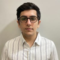 Person wearing glasses and a striped shirt against a plain background